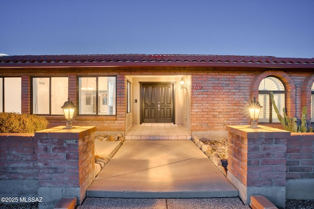 doorway to property with brick siding