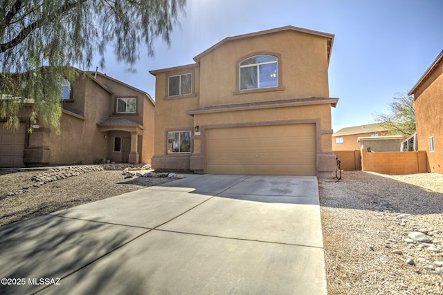 view of front of house featuring driveway, fence, an attached garage, and stucco siding