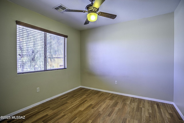 unfurnished room with wood finished floors, a ceiling fan, and baseboards