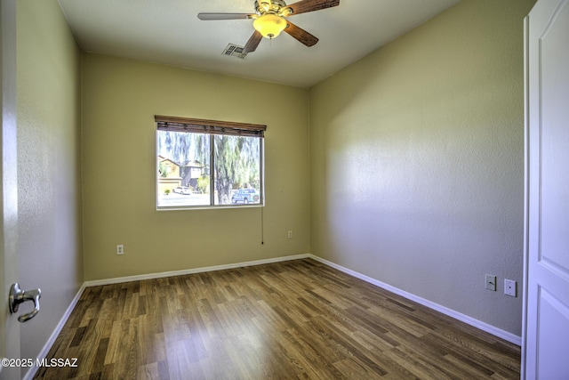 spare room with visible vents, ceiling fan, baseboards, and wood finished floors