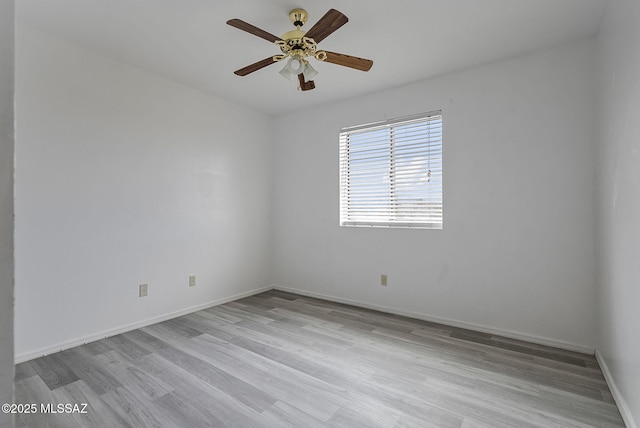 unfurnished room with wood finished floors, a ceiling fan, and baseboards