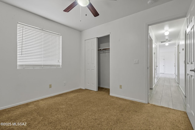 unfurnished bedroom featuring ceiling fan, light colored carpet, visible vents, baseboards, and a closet