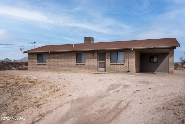 single story home with central AC and brick siding