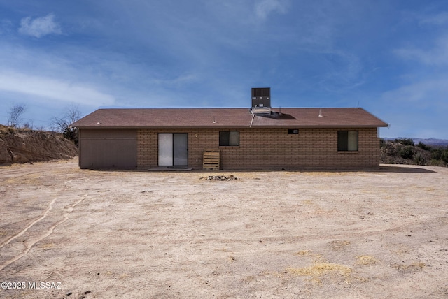 rear view of property with brick siding and central AC unit