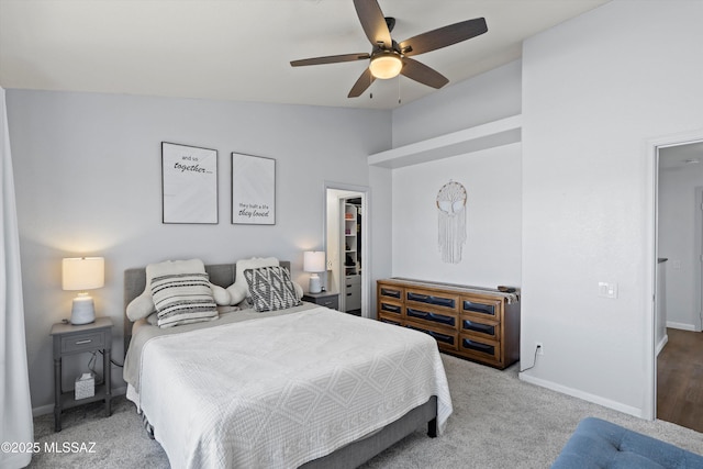 carpeted bedroom featuring lofted ceiling, a closet, baseboards, a spacious closet, and a ceiling fan
