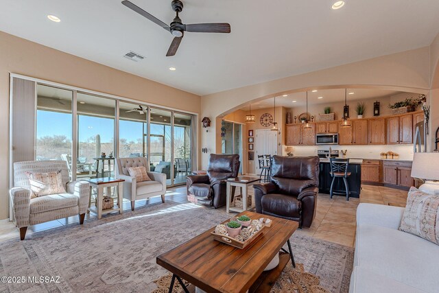 living room with visible vents, recessed lighting, arched walkways, light tile patterned floors, and ceiling fan