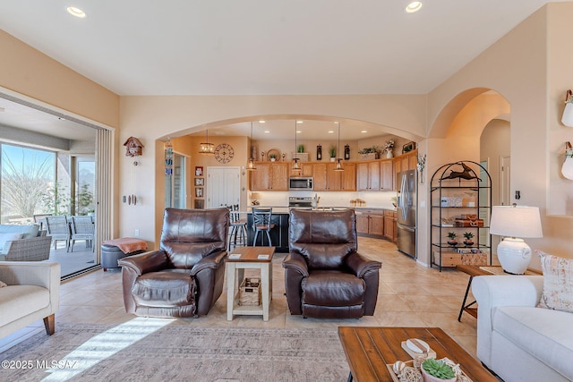 living room with light tile patterned floors, recessed lighting, and arched walkways