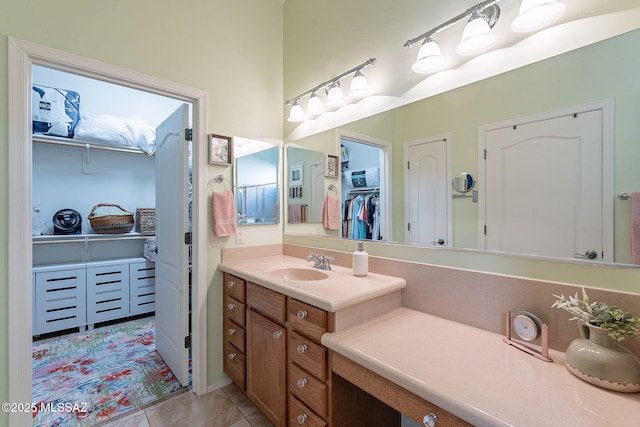 bathroom with vanity, a spacious closet, and tile patterned flooring