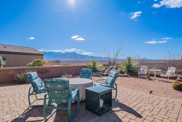 view of patio / terrace with fence and a mountain view