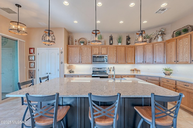 kitchen with light tile patterned floors, visible vents, a sink, decorative backsplash, and appliances with stainless steel finishes