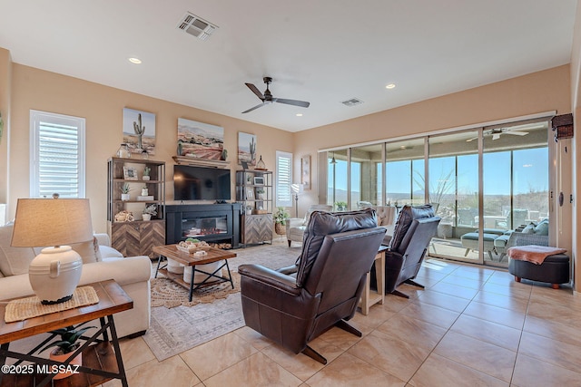 living area with recessed lighting, visible vents, a glass covered fireplace, and light tile patterned flooring