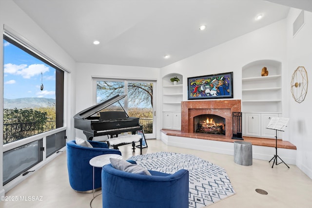 living area with built in shelves, a high end fireplace, visible vents, and recessed lighting