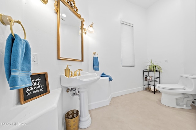 bathroom with toilet and baseboards