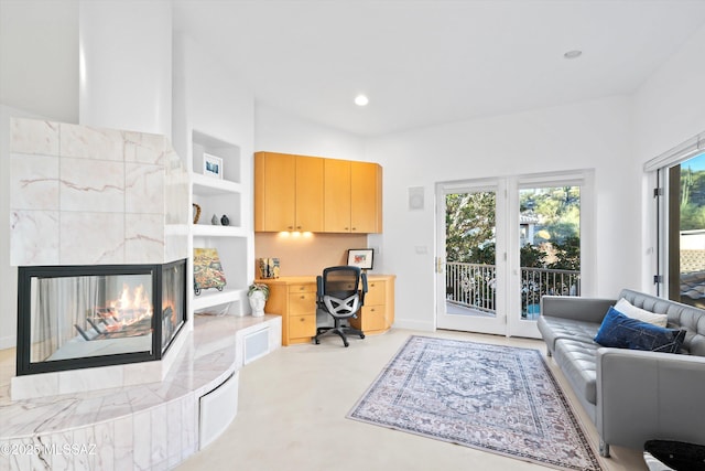 office area featuring concrete flooring, a fireplace, built in features, and recessed lighting