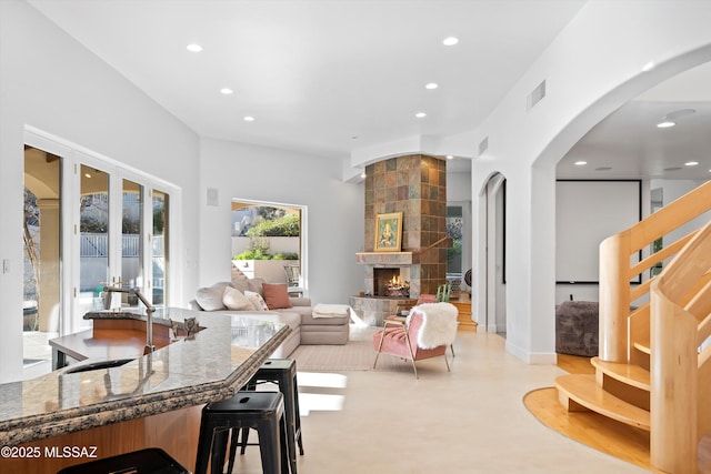 interior space with a large fireplace, visible vents, a sink, and recessed lighting