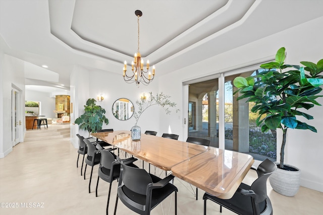 dining space with a chandelier, a tray ceiling, and a healthy amount of sunlight