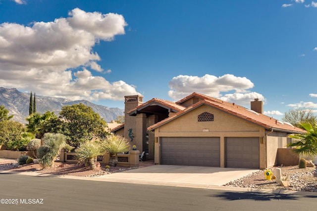 mediterranean / spanish house featuring stucco siding, a mountain view, a garage, and driveway