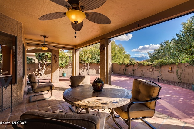 view of patio with outdoor dining space, a fenced backyard, and ceiling fan