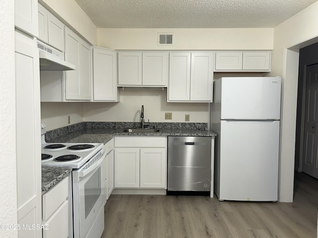 kitchen featuring visible vents, light wood-style flooring, a sink, white appliances, and under cabinet range hood