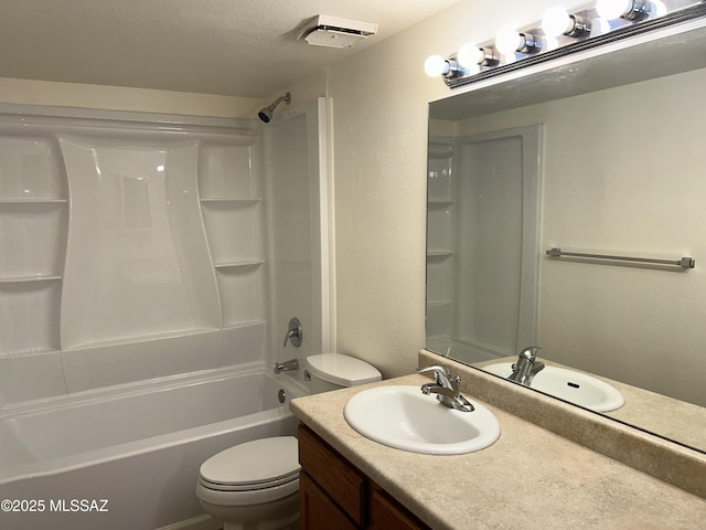 bathroom featuring a textured wall, tub / shower combination, vanity, and toilet