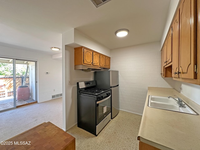 kitchen with visible vents, brown cabinetry, light countertops, a sink, and stainless steel appliances