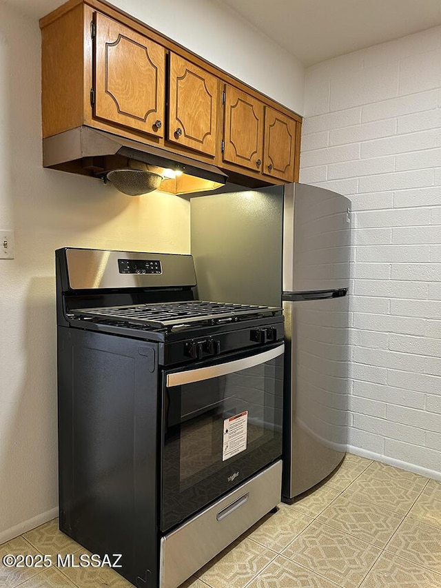 kitchen with gas stove, baseboards, under cabinet range hood, and brown cabinets