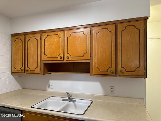 kitchen with a sink, dishwasher, brown cabinets, and light countertops