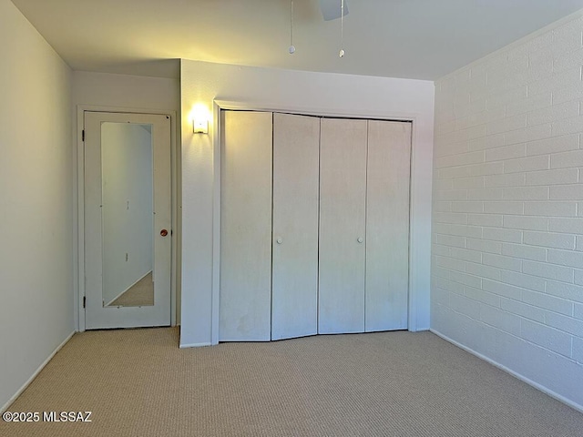 unfurnished bedroom featuring carpet floors, baseboards, and a closet