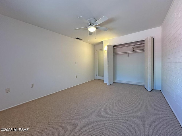 unfurnished bedroom with visible vents, a ceiling fan, a closet, and light carpet