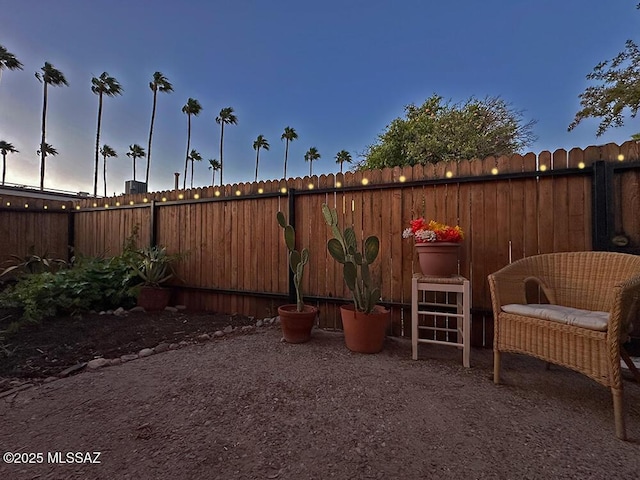 patio terrace at dusk with a fenced backyard