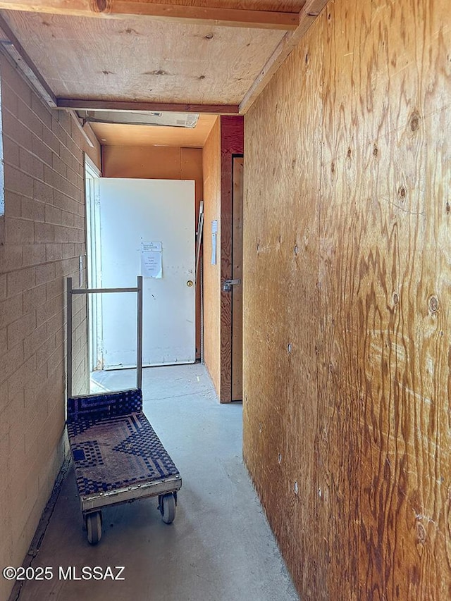 corridor with concrete flooring and concrete block wall