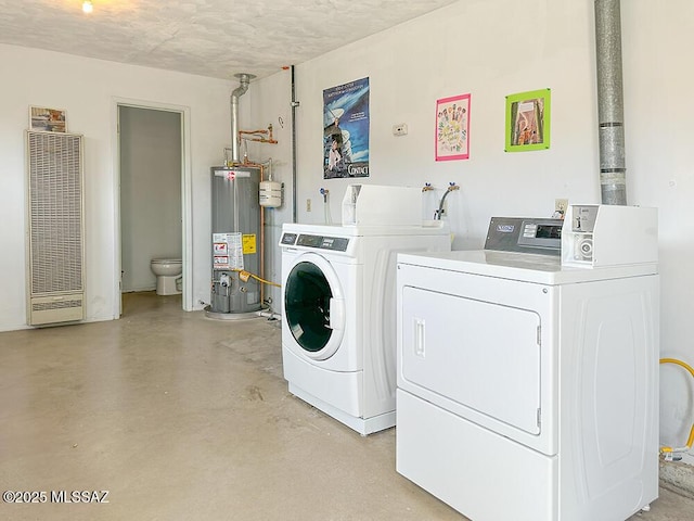 washroom with gas water heater, washer and clothes dryer, and a heating unit