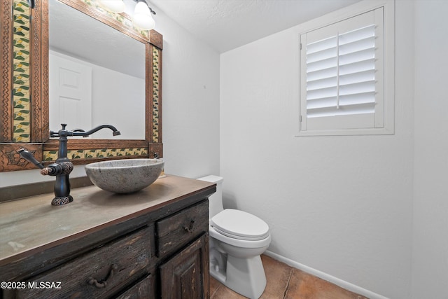 half bathroom with tile patterned flooring, toilet, vanity, and baseboards