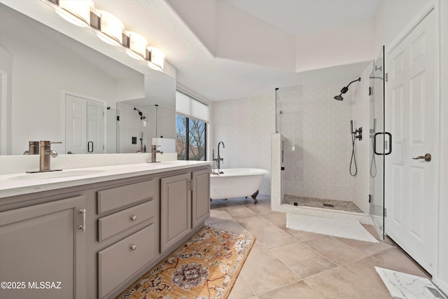 bathroom featuring double vanity, a soaking tub, a stall shower, and a sink