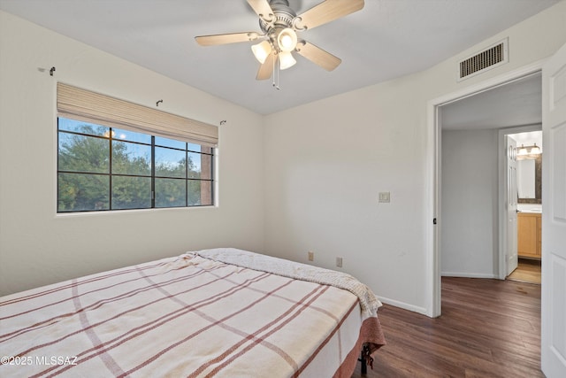 bedroom with visible vents, baseboards, wood finished floors, and a ceiling fan