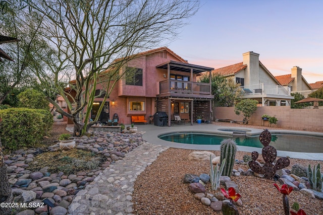 view of pool featuring a pool with connected hot tub, a patio, and fence