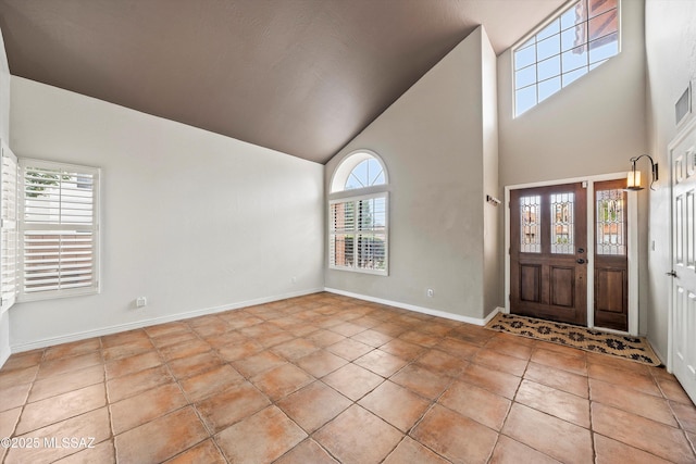 entrance foyer featuring tile patterned floors, baseboards, and vaulted ceiling