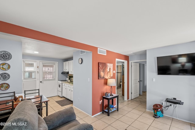 living area with light tile patterned floors, visible vents, and baseboards