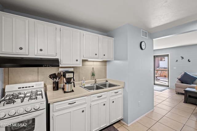 kitchen with light countertops, visible vents, a sink, under cabinet range hood, and white gas range oven