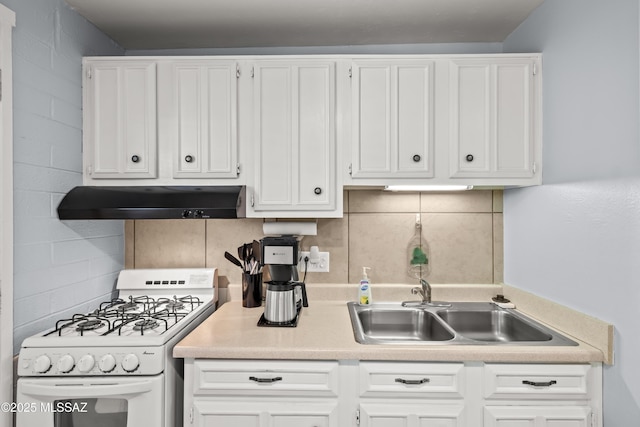 kitchen with under cabinet range hood, a sink, white cabinets, and white range with gas cooktop