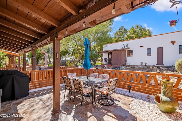 view of patio featuring outdoor dining area, fence, and area for grilling