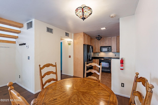 dining room featuring dark wood-style floors, visible vents, and baseboards