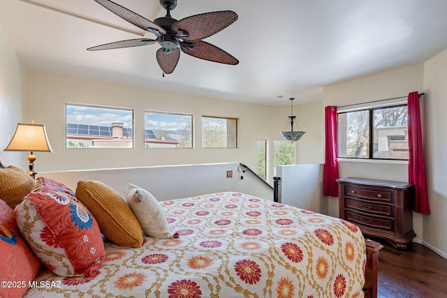 bedroom with a ceiling fan, baseboards, and wood finished floors