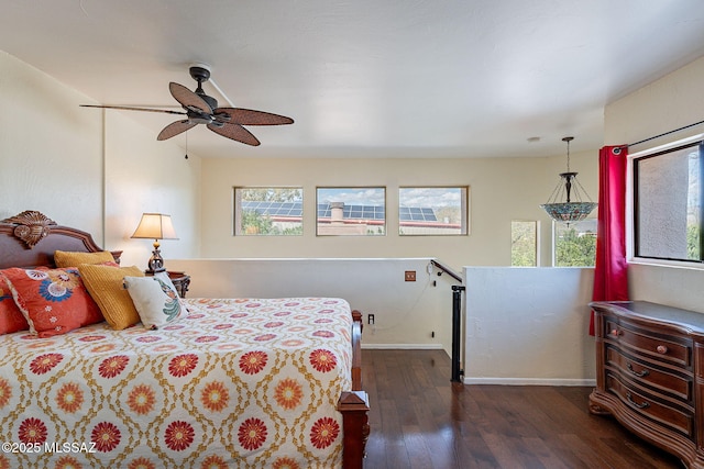 bedroom featuring dark wood finished floors, a ceiling fan, and baseboards