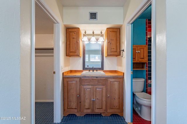 bathroom featuring visible vents, toilet, vanity, and tile patterned flooring