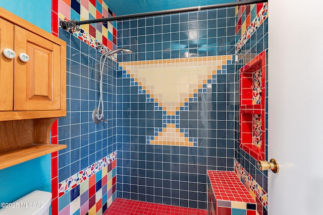 full bathroom with a tile shower and toilet