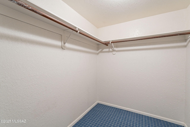 spacious closet with dark tile patterned floors