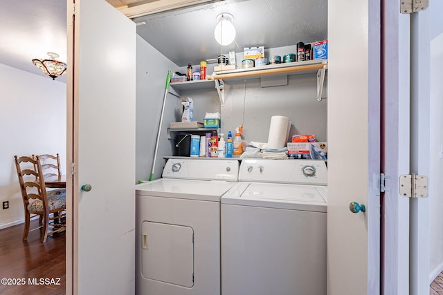 clothes washing area featuring washing machine and clothes dryer, laundry area, and dark wood finished floors