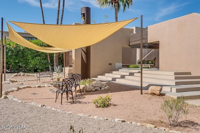 exterior space with stucco siding and a patio