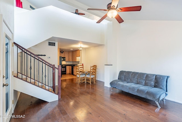 living area with visible vents, a high ceiling, wood finished floors, and stairway